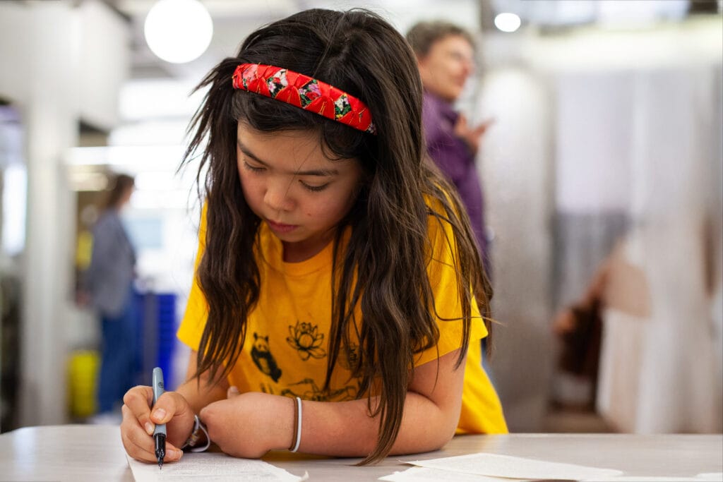 young girl writing on a piece of paper